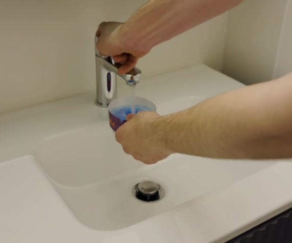 AshMe vullen met water bij de kraan